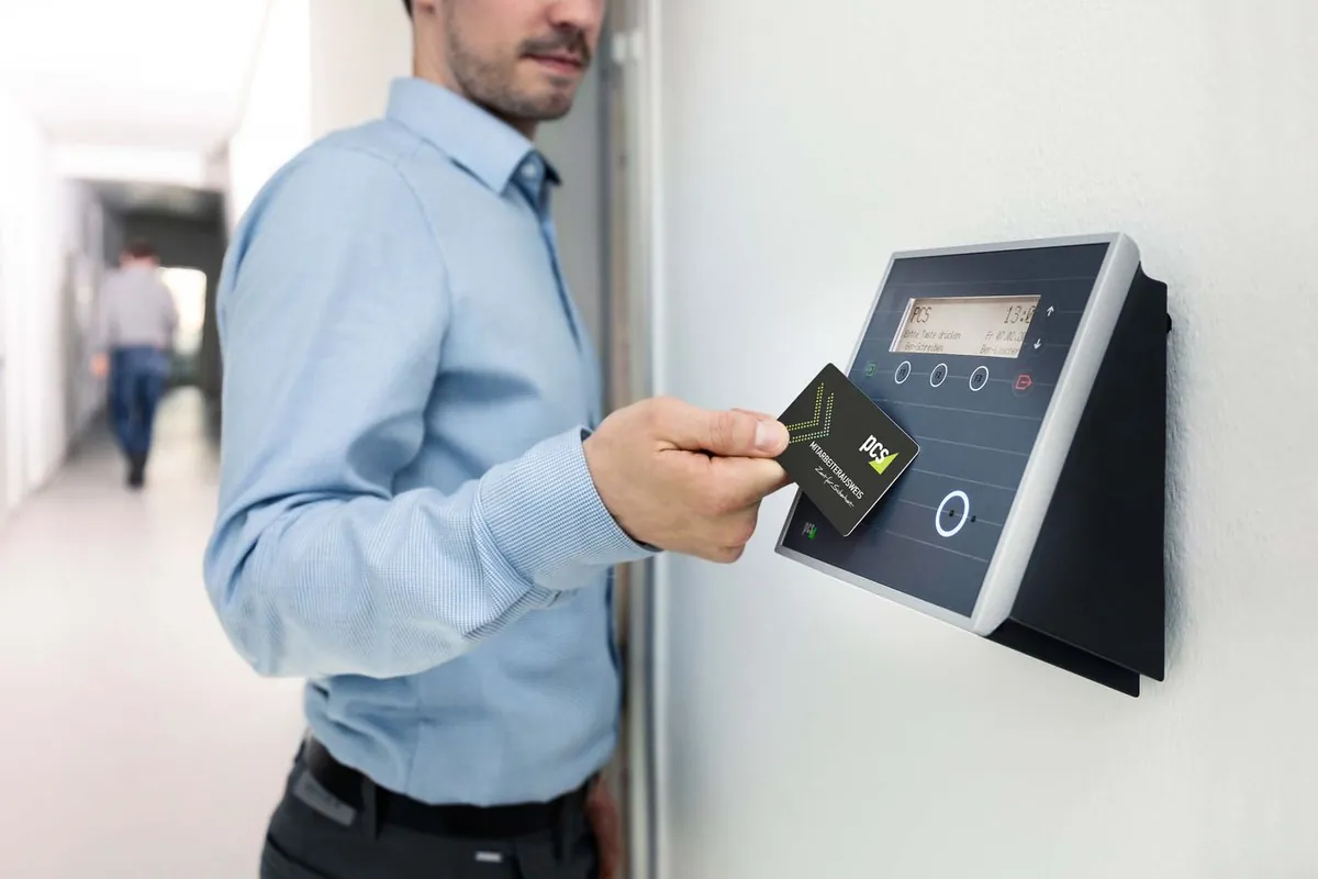 Person entering an office doorway using an access badge reader
