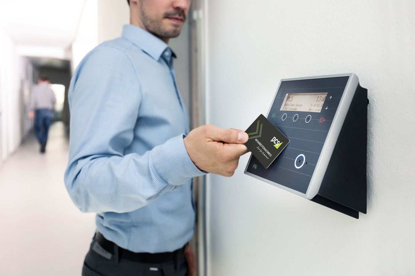 Person using an electronic badge reader at a controlled doorway